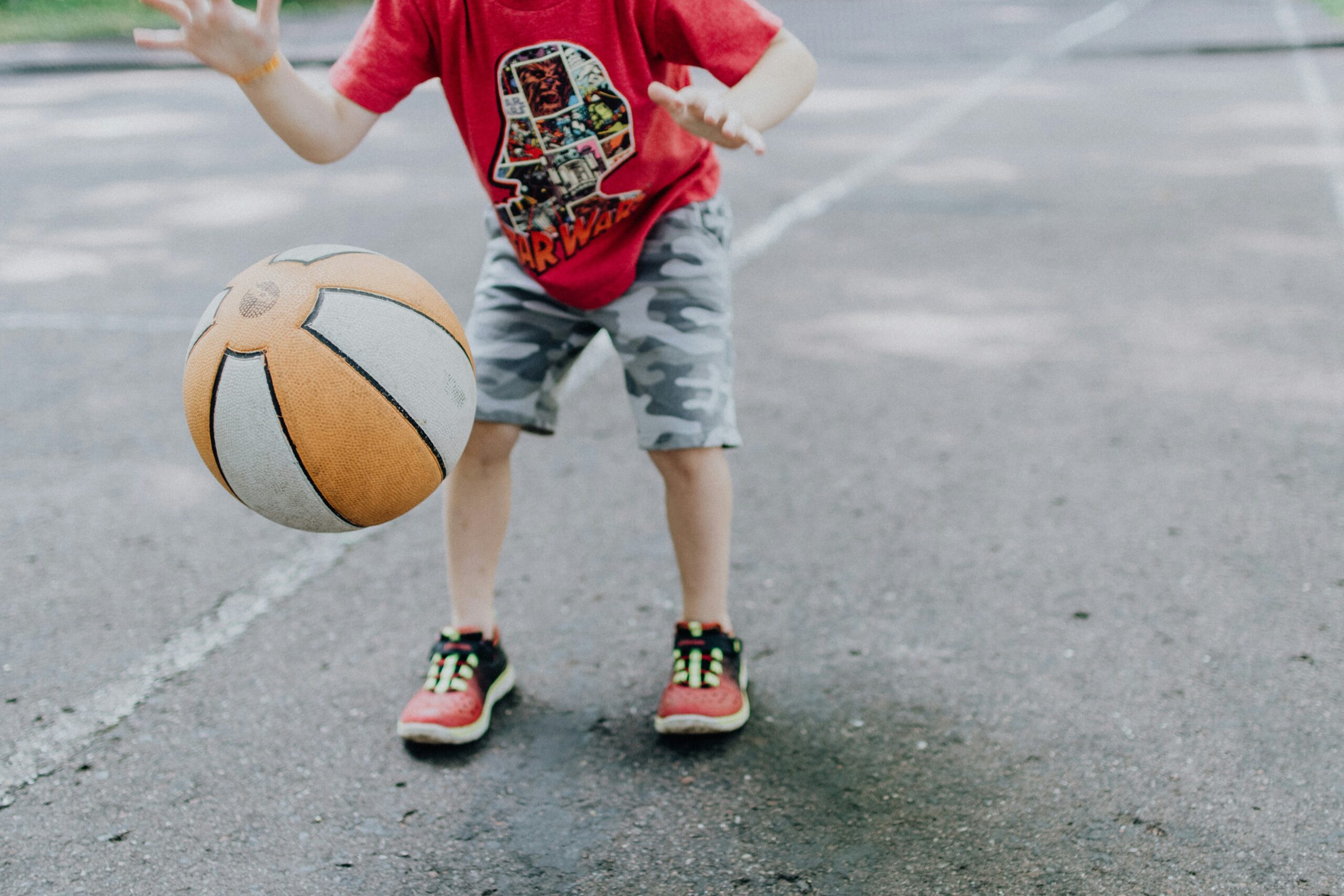 A child plays with a ball outdoors during the day
