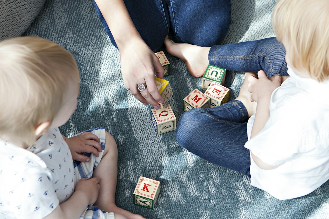 Learning Center Two toddlers playing together with letter blocks